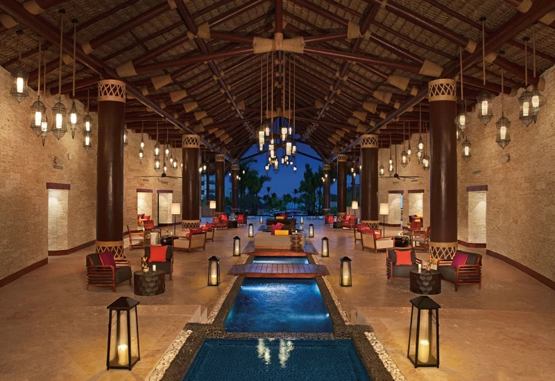 A spacious lobby with a central water feature, multiple seating areas, and hanging lanterns.