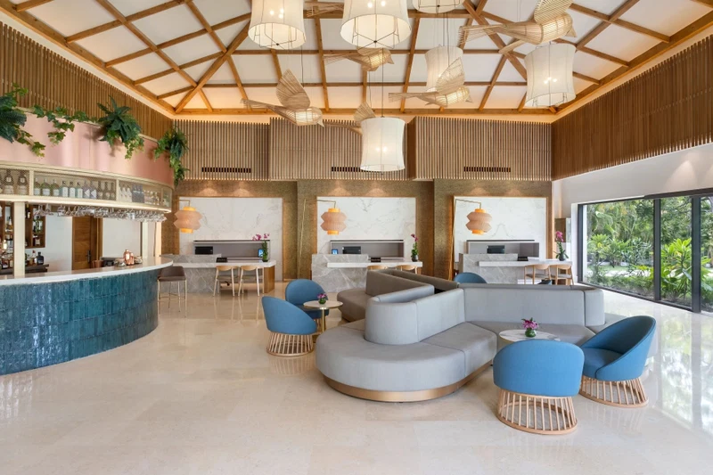 A modern lobby with a curved seating area, a reception desk, and a bar.