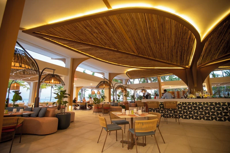 A spacious indoor area with high ceilings, large windows, and a variety of seating arrangements including tables and chairs.