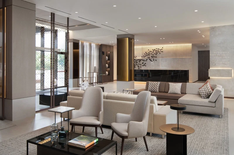 A modern living room with a large sofa, armchairs, a coffee table, and a fireplace.
