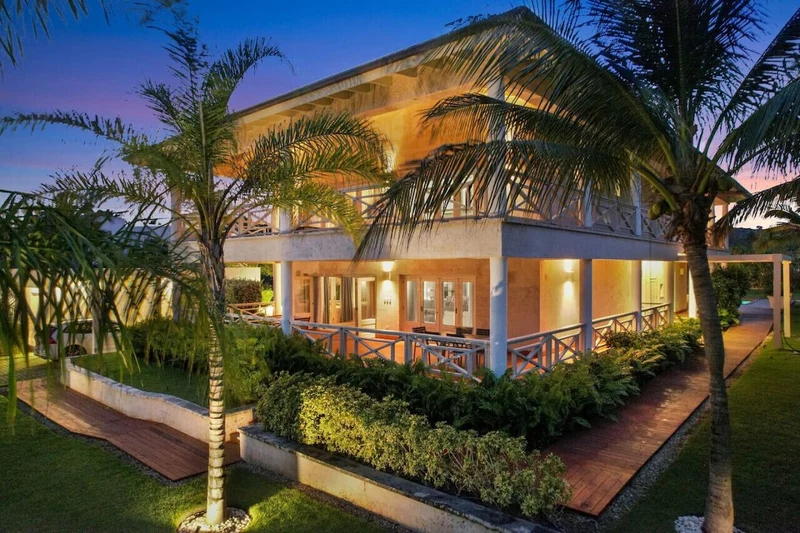 A two-story building with a covered outdoor area, surrounded by palm trees and well-maintained landscaping.
