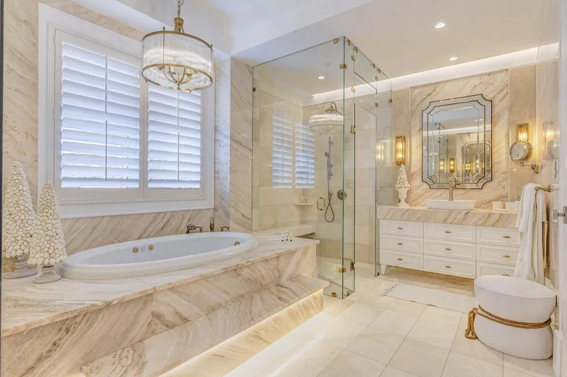 A luxurious bathroom with a marble bathtub, a glass-enclosed shower, and a large mirror.