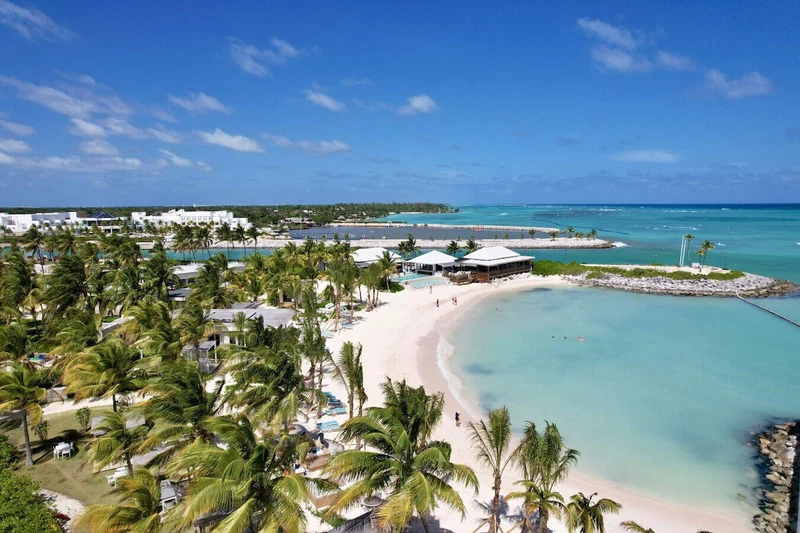 A beach resort with multiple pools, palm trees, and a sandy beach.