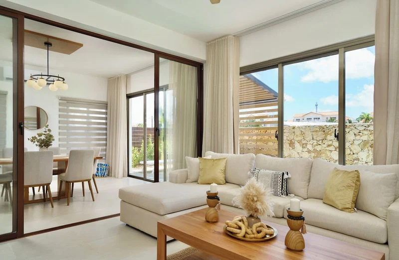 A modern living room with a sofa, coffee table, and dining area.