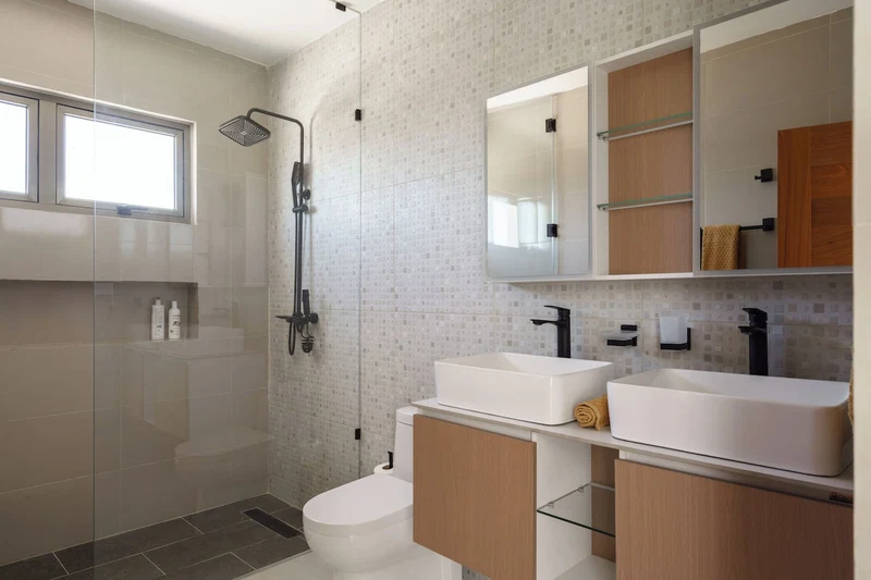 A modern bathroom with a shower, two sinks, a toilet, and a large mirror.