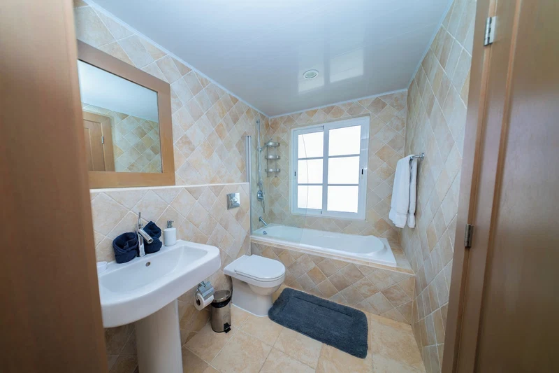 A bathroom with a sink, toilet, and shower area.