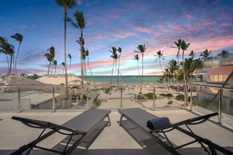 A beachside resort with lounge chairs and a view of the ocean.