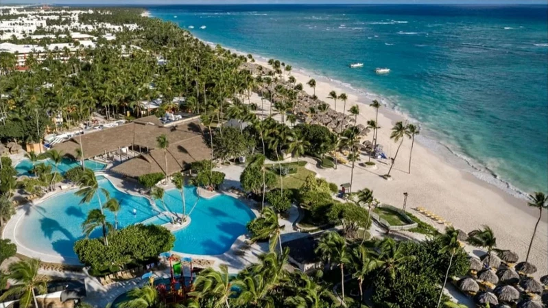 A resort with a large pool, beach, and ocean views.