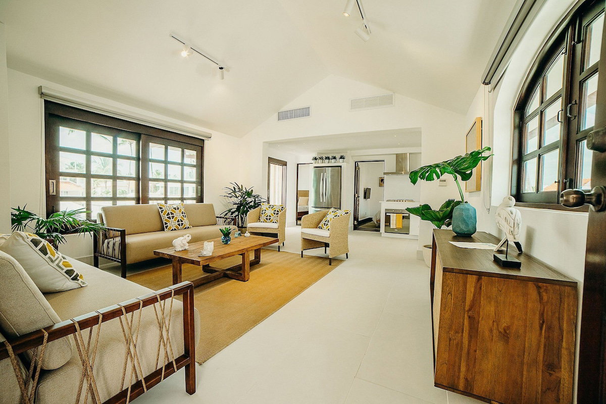 A spacious living room with a sofa, chairs, a coffee table, and a wooden cabinet.