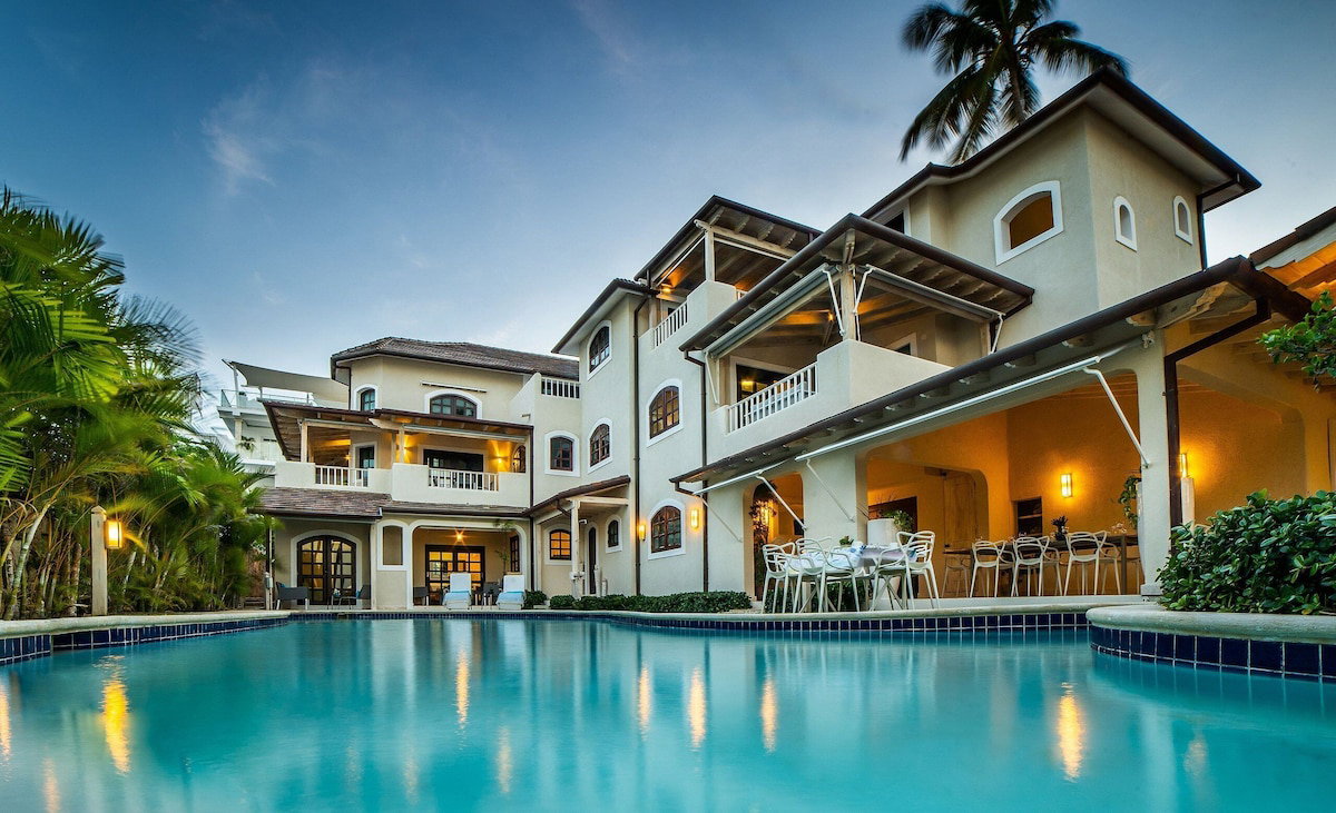 A large, multi-story building with a swimming pool in the foreground.