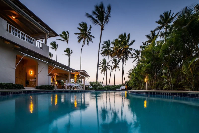 A swimming pool with a view of a building and palm trees.