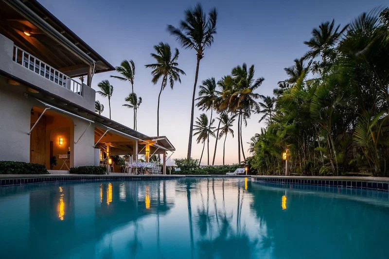 A swimming pool with a view of a building and palm trees.