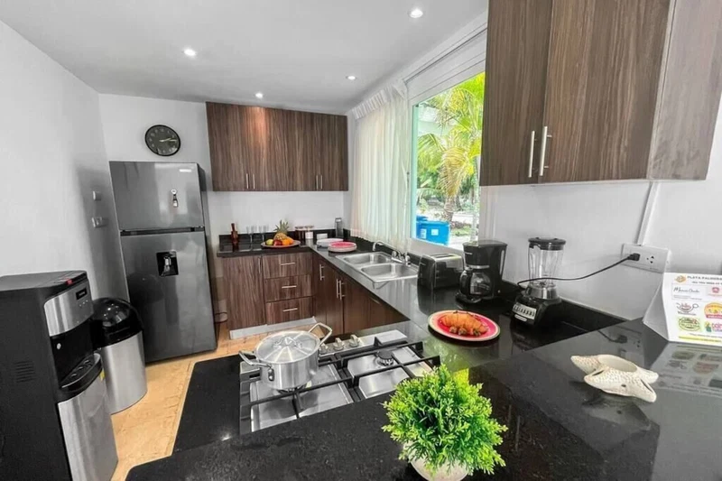 A modern kitchen with a stainless steel refrigerator, a coffee maker, and a gas stove.